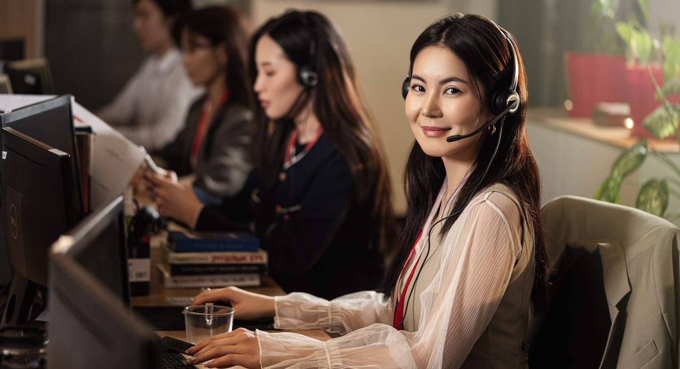 Operadora de televendas com headset atendendo cliente em uma estrutura de inside sales